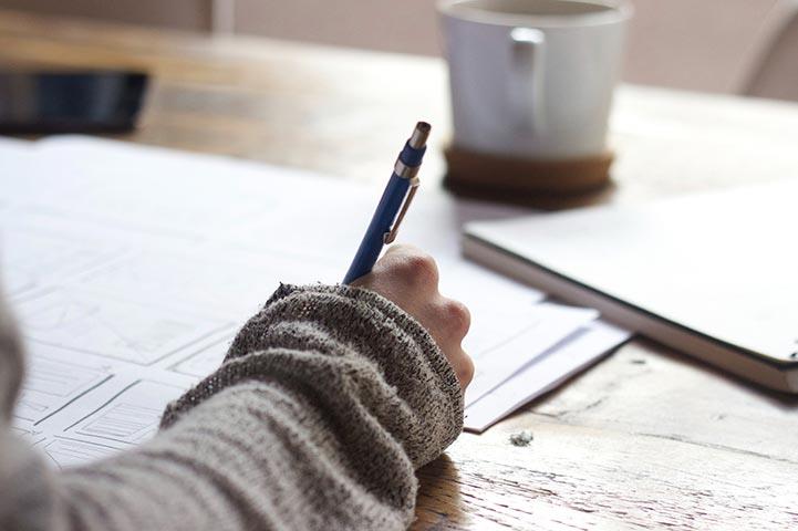 hand writting on paper with green sweater